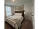 Well-lit bedroom featuring a neutral palette, comfortable bed, and a calming landscape painting at 639 Longboat Dr, Davenport, FL 33896