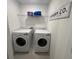 Convenient laundry room with modern washer and dryer and practical shelving at 639 Longboat Dr, Davenport, FL 33896