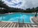 Spacious swimming pool with crystal clear water, surrounded by lounge chairs and lush greenery at 639 Longboat Dr, Davenport, FL 33896
