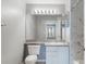 Bathroom features white vanity, mirror, and marble-look shower at 7511 Seurat St # 10207, Orlando, FL 32819