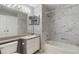 This renovated bathroom has modern white marbled tile, and a single sink vanity at 7511 Seurat St # 10207, Orlando, FL 32819