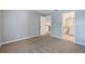 An airy bedroom includes a door leading to a bathroom, a door leading to the kitchen, with neutral walls and carpeted floor at 7511 Seurat St # 10207, Orlando, FL 32819