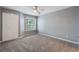 Neutral bedroom with carpet, ceiling fan, window, and double door closet at 7511 Seurat St # 10207, Orlando, FL 32819