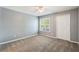 This cozy bedroom features neutral walls, carpet flooring, and a window that allows natural light to illuminate the space at 7511 Seurat St # 10207, Orlando, FL 32819