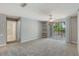 Bright living room features neutral paint, ceiling fan, shelving and sliding glass doors to the balcony at 7511 Seurat St # 10207, Orlando, FL 32819