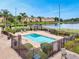 A fenced in pool area featuring a large pool, lounge chairs, and a covered gazebo overlooking a pond at 7511 Seurat St # 10207, Orlando, FL 32819