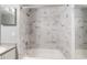 Shower with white marble-look tile and tub at 7511 Seurat St # 10207, Orlando, FL 32819