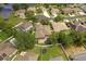 Expansive aerial view shows a neighborhood with a pond, pools, and well-maintained lawns at 7513 Brightwater Pl, Oviedo, FL 32765