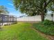 Expansive backyard featuring a lush lawn, mature trees, and a screened pool area at 7513 Brightwater Pl, Oviedo, FL 32765