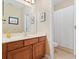 Bathroom with wood cabinets, white countertops, framed art, and a shower/tub combo at 7513 Brightwater Pl, Oviedo, FL 32765