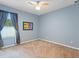 Carpeted bedroom with blue walls, a ceiling fan, a window, and art of The Beatles on the wall at 7513 Brightwater Pl, Oviedo, FL 32765