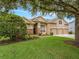 Charming two-story home featuring a three-car garage, stone accents, and lush landscaping at 7513 Brightwater Pl, Oviedo, FL 32765