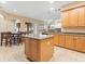 Spacious kitchen view showcasing an island, wooden cabinets, a dining table and backyard access at 7513 Brightwater Pl, Oviedo, FL 32765