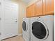 Functional laundry room with a washer, a dryer, and wood cabinetry at 7513 Brightwater Pl, Oviedo, FL 32765
