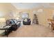 Warm living room featuring cozy seating, soft carpet, and seamless access to the dining area at 7513 Brightwater Pl, Oviedo, FL 32765