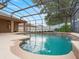 Beautiful pool area with a waterfall feature, lush landscaping, and a screened enclosure at 7513 Brightwater Pl, Oviedo, FL 32765