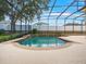 Relaxing pool with a screened enclosure, surrounding patio, and manicured landscaping at 7513 Brightwater Pl, Oviedo, FL 32765
