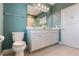 Bathroom with double sinks, toilet and a large mirror above the vanity at 8478 Karrer Ter, Orlando, FL 32827