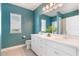 Bathroom with dual sink vanity with white cabinets, modern fixtures, and a toilet with blue walls at 8478 Karrer Ter, Orlando, FL 32827