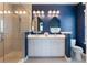 Bathroom features a double sink vanity, framed mirrors, and glass shower stall at 8478 Karrer Ter, Orlando, FL 32827