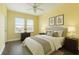 Bedroom features a full bed, yellow walls, two windows, ceiling fan, and two end tables with lamps at 8478 Karrer Ter, Orlando, FL 32827