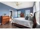 Comfortable blue bedroom with a wooden bed frame, dark floors, and plenty of natural light at 8478 Karrer Ter, Orlando, FL 32827