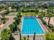 Aerial view of community lap pool with palm trees, lounge seating, and a nearby playground at 8478 Karrer Ter, Orlando, FL 32827