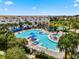 A beautiful community pool area featuring blue umbrellas, palm trees, and comfortable lounge seating at 8478 Karrer Ter, Orlando, FL 32827
