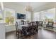 Bright dining room features a wooden table, elegant light fixture, and sun-filled windows at 8478 Karrer Ter, Orlando, FL 32827