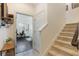 Hallway featuring carpeted staircase and a view into a living room with wood-look flooring at 8478 Karrer Ter, Orlando, FL 32827