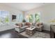 Bright living room featuring large windows, comfortable sofa, and stylish decor at 8478 Karrer Ter, Orlando, FL 32827