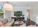 Bright living room with wood floors, comfortable seating, and a large television for entertainment at 8478 Karrer Ter, Orlando, FL 32827