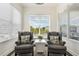 Cozy sitting area with two armchairs and abundant natural light from large windows at 8478 Karrer Ter, Orlando, FL 32827