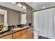 Bathroom with a double sink vanity, granite countertop, and shower/tub combo with curtain at 101 S Eola Dr # 810, Orlando, FL 32801