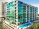 Stunning exterior view of a modern high-rise building with a pool deck and ample balconies with glass railings at 101 S Eola Dr # 810, Orlando, FL 32801