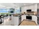 Modern kitchen with white cabinetry, stainless steel appliances, and adjacent view of the living area and expansive windows at 101 S Eola Dr # 810, Orlando, FL 32801
