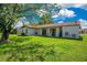 View of the rear of home with lush lawn, patio and mature trees at 10148 Eventide Ct, Orlando, FL 32821