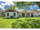 View of the rear of home with lush lawn, patio and mature trees at 10148 Eventide Ct, Orlando, FL 32821