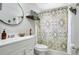Bathroom features a sink with a patterned shower curtain and a round mirror at 10148 Eventide Ct, Orlando, FL 32821