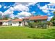 A cozy single-story home with a red tile roof, neat landscaping, and a well-kept green lawn at 10148 Eventide Ct, Orlando, FL 32821