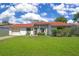 Charming single-story home featuring a well-manicured lawn and vibrant red-tiled roof at 10148 Eventide Ct, Orlando, FL 32821