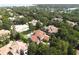 Breathtaking aerial shot of a luxury estate featuring a pool, lush greenery, and scenic views of a nearby lake at 11013 Ullswater Ln, Windermere, FL 34786