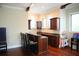 Wet bar area with stone countertops, rich wood cabinets, seating, and a playful ' area at 11013 Ullswater Ln, Windermere, FL 34786