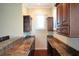 Elegant bar area with stone counters, dark wood cabinets, and plenty of natural light from the windows at 11013 Ullswater Ln, Windermere, FL 34786