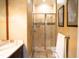 Bathroom boasts a spacious shower, dark wood vanity, and marble countertops with unique, decorative walls at 11013 Ullswater Ln, Windermere, FL 34786