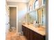 Spacious bathroom with marble countertops, double sinks, dark wood cabinets, and natural light at 11013 Ullswater Ln, Windermere, FL 34786