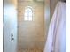 Modern shower boasts pebble flooring, arched window and sleek fixtures for a spa-like experience at 11013 Ullswater Ln, Windermere, FL 34786