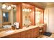 Bathroom features a vanity with double sinks, decorative columns, and warm lighting at 11013 Ullswater Ln, Windermere, FL 34786