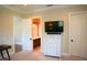 Bright bedroom with carpet, white dresser with TV, and adjacent bathroom with marble countertops at 11013 Ullswater Ln, Windermere, FL 34786