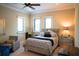 Cozy bedroom features natural light from multiple windows and comfortable seating area with a relaxing chair at 11013 Ullswater Ln, Windermere, FL 34786